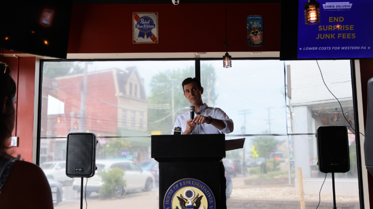 Rep. Deluzio stands behind a podium and gives remarks