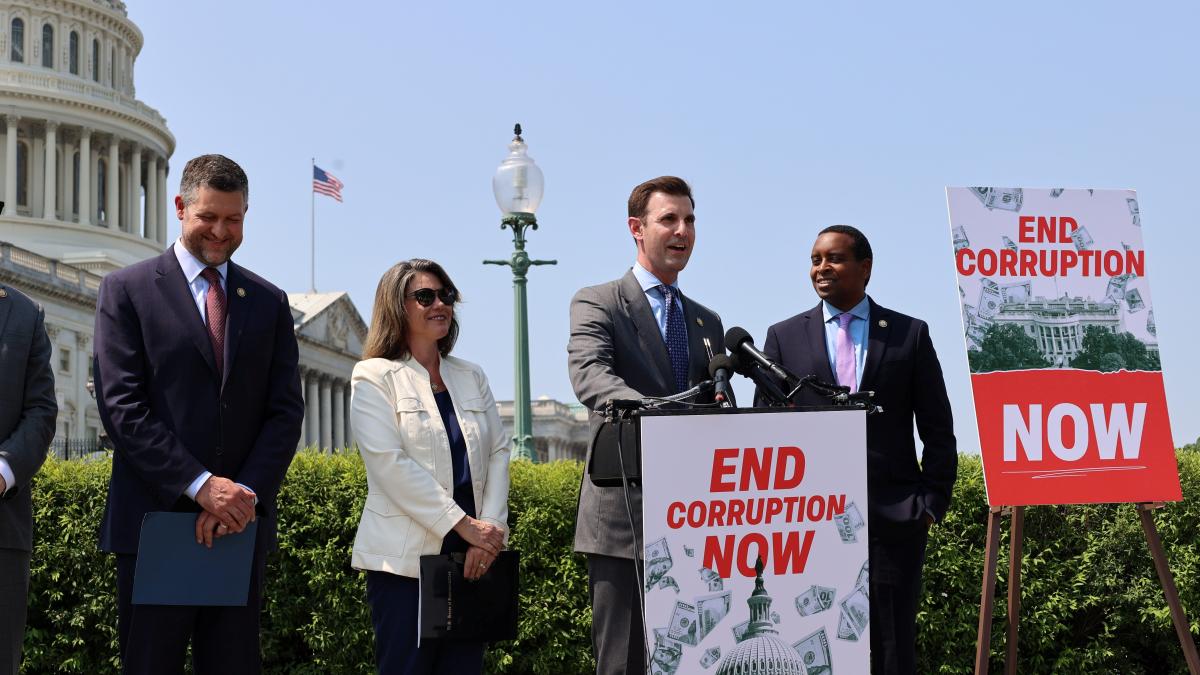 A photo of Congressman Deluzio and colleagues speaking in front of the Capitol at a podium with a sign that says "End Corruption Now"