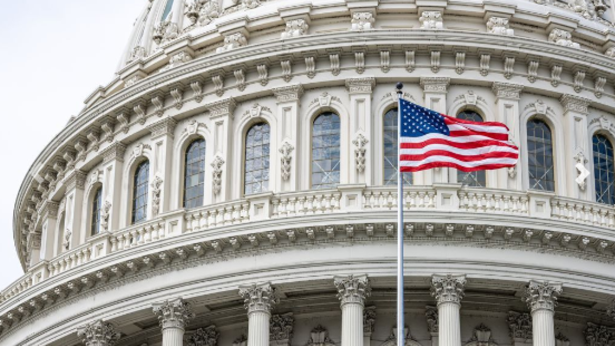 An American flag flies in front of the Capitol Dome