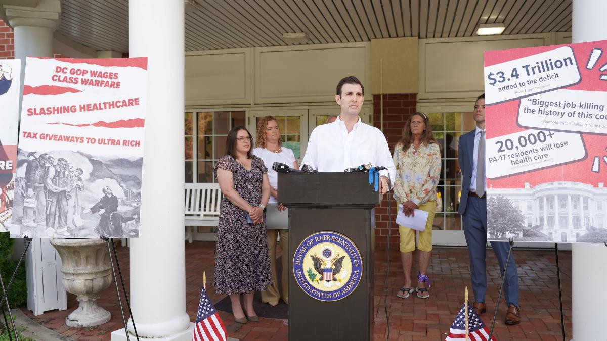 Rep. Deluzio stands behind a podium speaking at a press conference