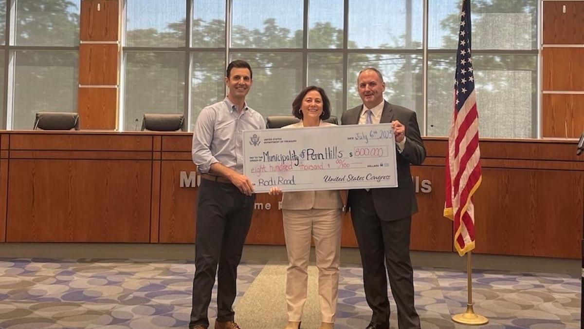Rep. Deluzio holds a check for $800,000 for Penn Hill Municipality.