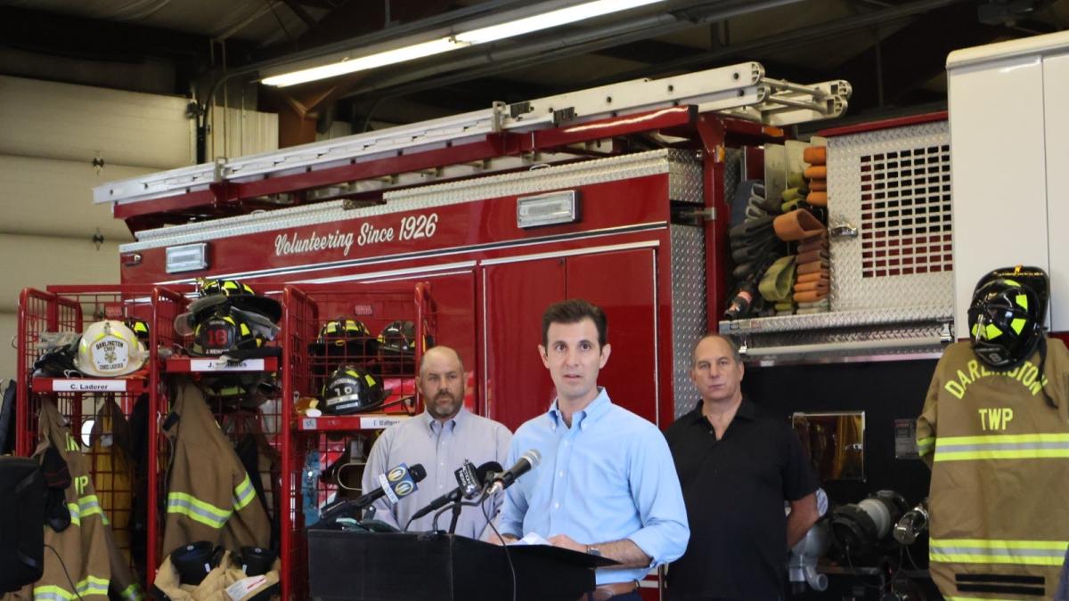 Rep. Deluzio stands in front of a fire truck and gives a speech on rail safety