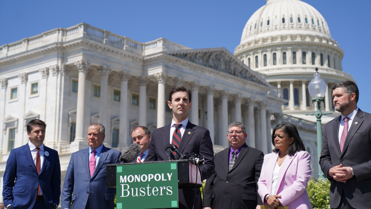 Congressman Deluzio speaking at a podium in front of the U.S. Capitol building, joined by colleagues and small business owners