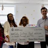 A photo of Congressman Deluzio and the owners of the Early Excellence Project holding a large federal check for $600,000