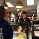 A photo of Congressman Deluzio serving lunch behind a school lunch counter
