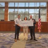 Rep. Deluzio holds a check for $800,000 for Penn Hill Municipality.