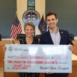 Rep. Deluzio holds a large check alongside a woman