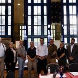 Rep. Deluzio stands with members of his Veterans Advisory Council in front of three windows